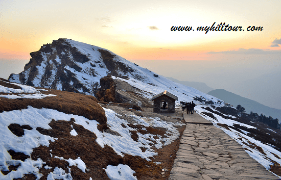 Scenic view of snow-covered trail at sunset during Chopta trekking package in Uttarakhand Himalayas, India