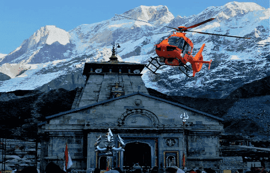 Helicopter landing at Kedarnath temple with snow-covered peaks during Do Dham Yatra By Helicopter tour